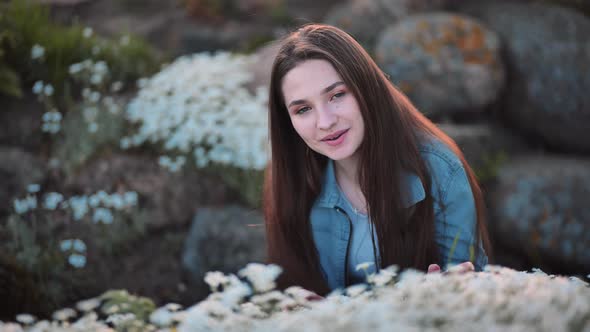 Longhaired Girl Posing and Smiling with White Flowers