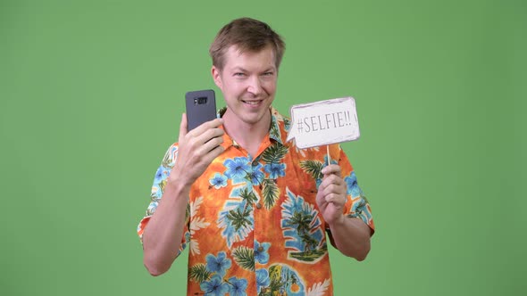 Young Handsome Tourist Man Holding Phone and Selfie Paper Sign