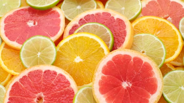 Slices Citrus fruits oranges, grapefruits, limes close. up, rotation. 4K UHD video