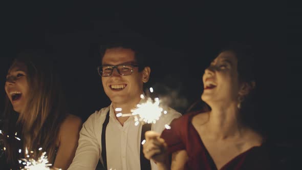 Large Group of Multiracial Friends or Acquaintances Holding and Waving Sparklers