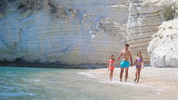 Happy Beautiful Family of Dad and Kids on White Beach