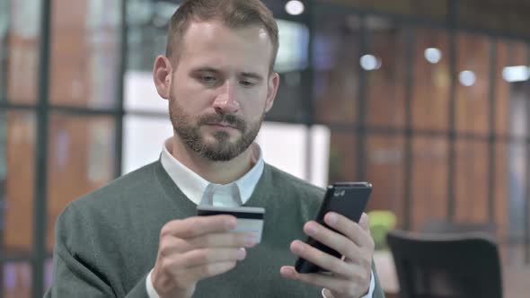 Portrait Shoot of Young Man Adding Credit Card in Cellphone