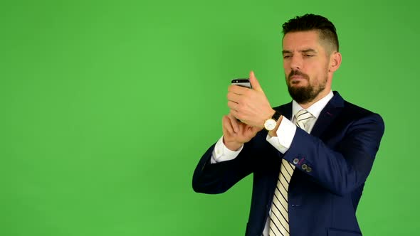 Business Man Photographs with Phone, Smartphone, Green Screen, Studio