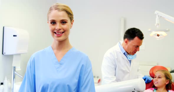 Smiling dental assistant standing in dental clinic