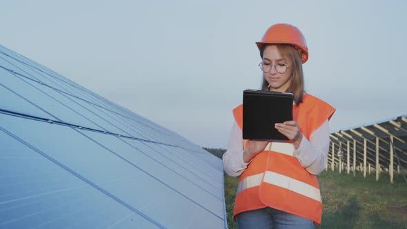 Inspector Engineer Woman Holding Digital Tablet Working in Solar Panels Power Farm
