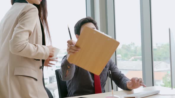 Two Business People Talk Project Strategy at Office