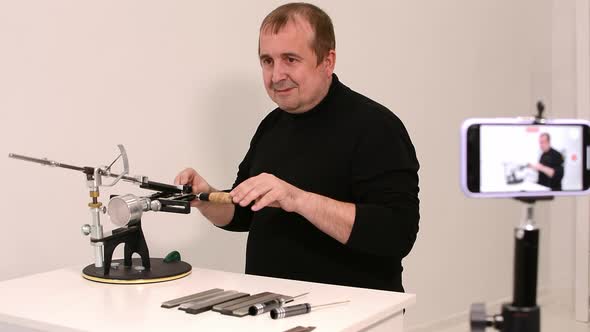 Man Shows a Master Class on Sharpening a Knife on a Machine