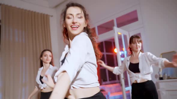 Four Girls in Black Skirts and White Shirts are Dancing Indoors