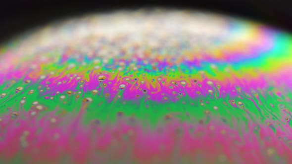 Macro shot of a soap bubble creates a colorful and psychedelic background. Rainbow colors