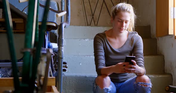 Woman using mobile phone at workshop 