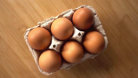 close up of brown eggs in egg carton on rustic background