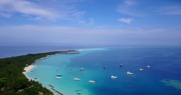 Natural flying tourism shot of a summer white paradise sand beach and aqua blue water background 