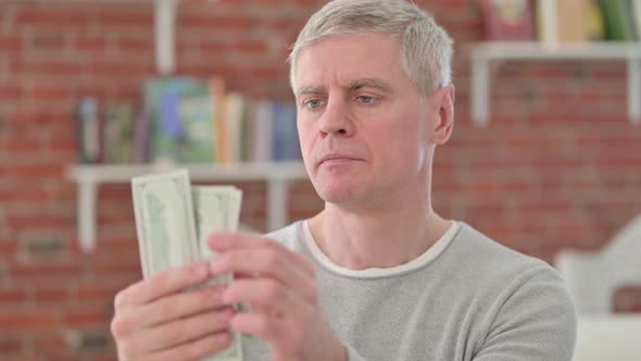 Wise Senior Old Man Counting Dollars