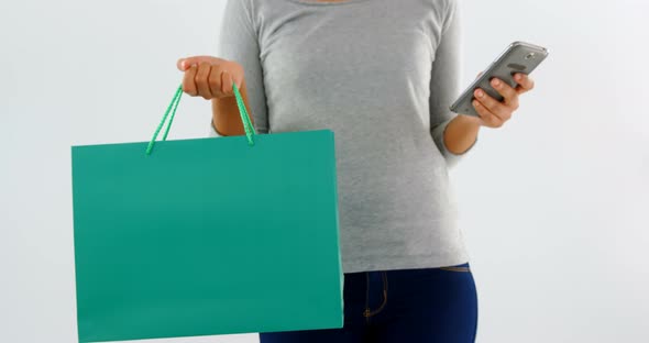 Woman standing with shopping bag and mobile phone 4k