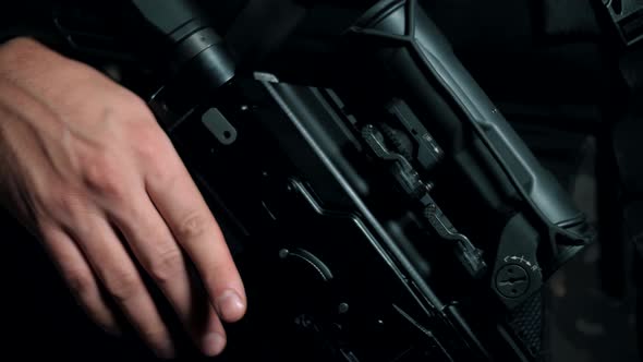 Man with a modern Kalashnikov assault rifle in a body kit. Close-up. Black background