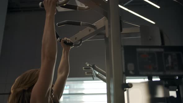 Beautiful Caucasian Girl Doing Pullups on the Gravitron