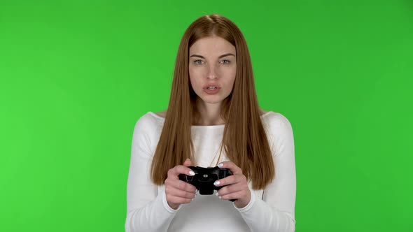 Portrait of Pretty Young Woman Is Playing a Video Game Using a Wireless Controller with Joy and Wow
