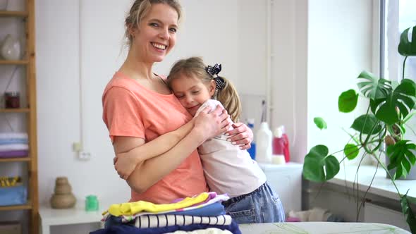 Portrait of Affectionate Mother Embracing Daughter While Doing Domestic Chores Spbd