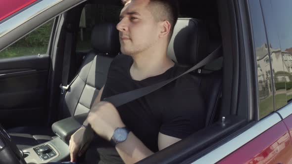 Driver Fastens and Unfastens Seat Belt while sitting in the Car