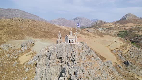 Epic Cinematic Aerial photography drone shot of a small white chapel on a hill with a Christ cross