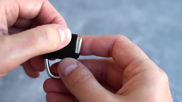 Closeup of Mans Hand Opening Combination Lock