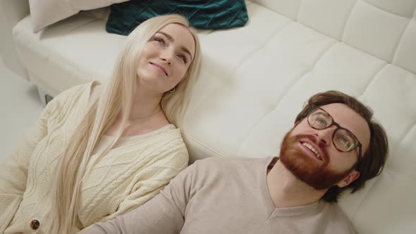 European Blonde Longhaired Woman Laying Down with Her Brunet Bearded Boyfriend and Smiling