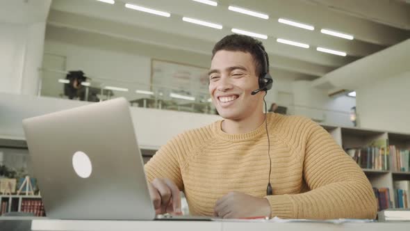 Smiling Handsome Latinos Man Communicates Via Video Link with a Headset on His Head, Mixed Race Man