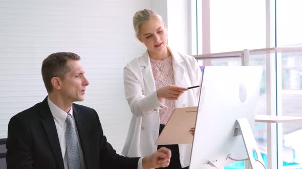 Two Business People Talk Project Strategy at Office