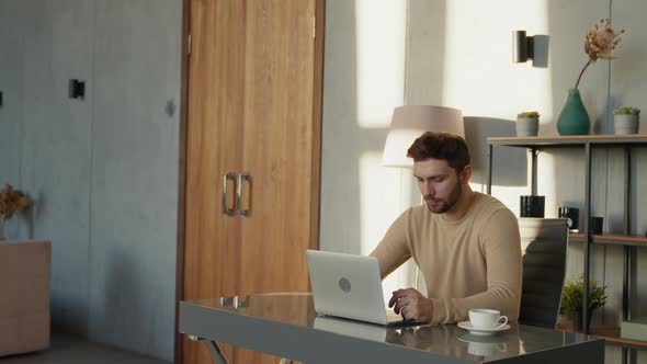 Emotional man with laptop at work in home office