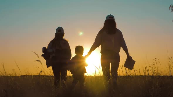 Happy Family Mom and Children Silhouettes Playing on Park