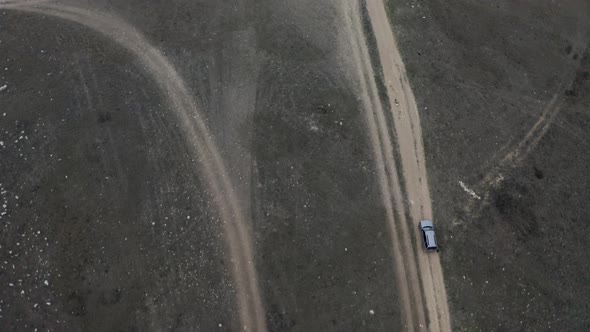 Aerial Shot High Speed Suv Automobile Riding on Countryside Road at Meadow Approaching to Cliff