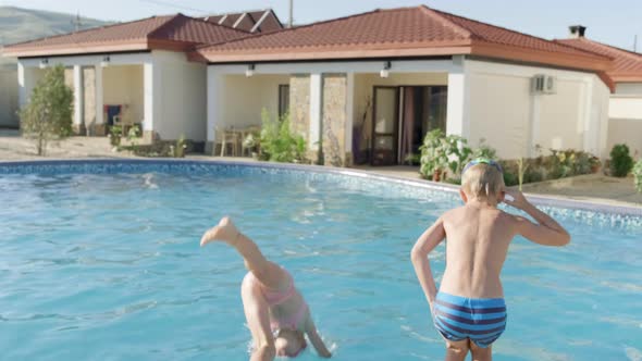 Back View Happy Boy and Girl Running and Jumping in Swimming Pool Children Having Fun Splashing