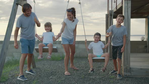Big Cheerful Family Having Fun on a Swing.