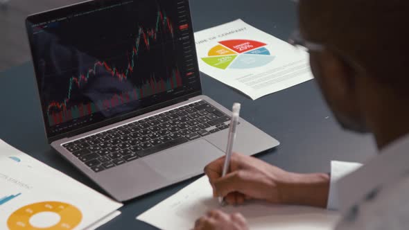 Young businessman working with laptop at the desk in the office