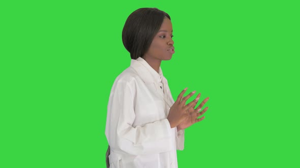 Young African American Female Doctor Talking As She Walks on a Green Screen Chroma Key