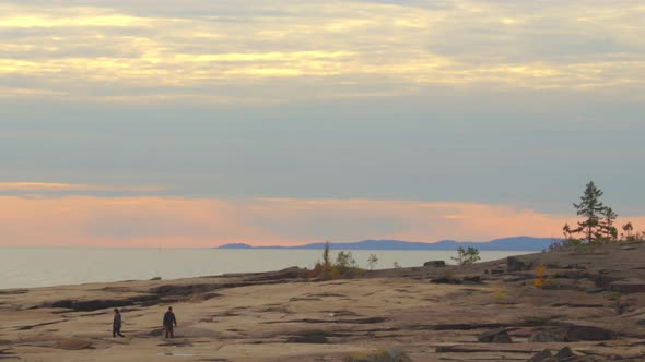 People walking near shore in dreamy sunset