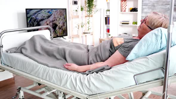 Old Female Lying on Bed in a Retirement Home