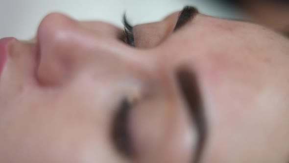 Closeup Eye of Young Slim Woman in Beauty Salon Doing Permanent Eyebrow Tattooing