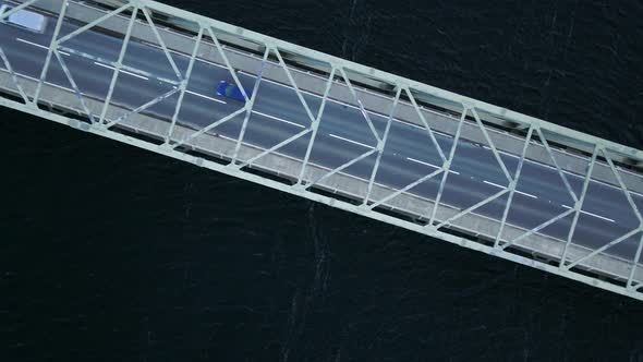 Bird's Eye View of a Bridge Spanning a Fast Flowing Dark River