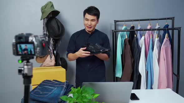 man selling shoes and clothes online by camera live streaming, business online e-commerce at home