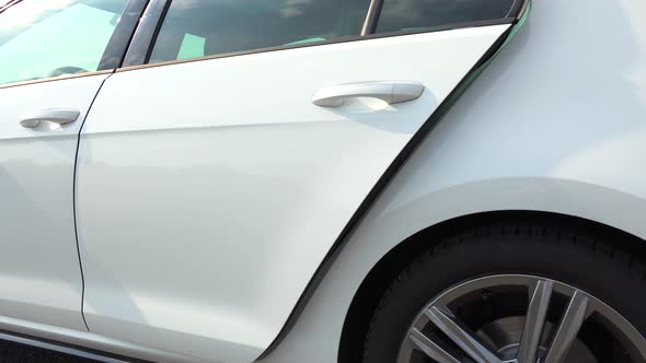 A Young Beautiful Woman Gets Out of a White Luxurious Car - Closeup