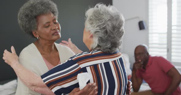 Diverse group of senior friends giving support to african american female friend on meeting