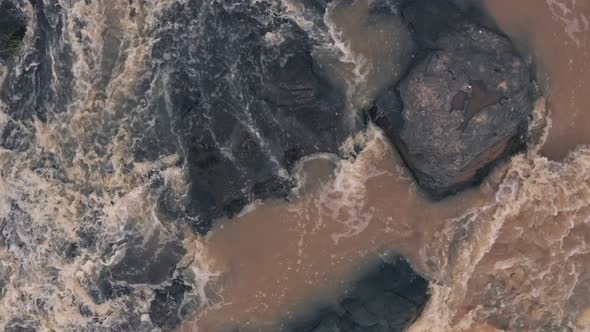 Drone travels over edge of waterfall in river in Laikipia, Kenya, Top down aerial view