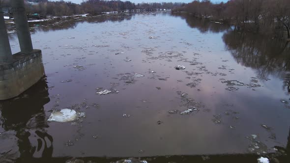 Dirty White Ice Floes Float Along the Slow River