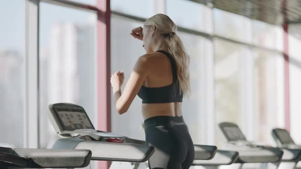 Running Woman Practicing on Treadmill Machine in Fitness Gym