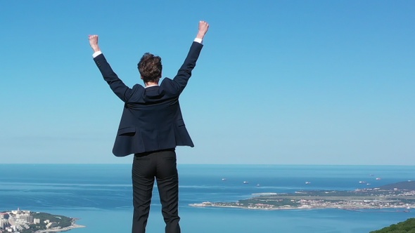 Businessman Reaching Top of Mountain. Concept of Success.