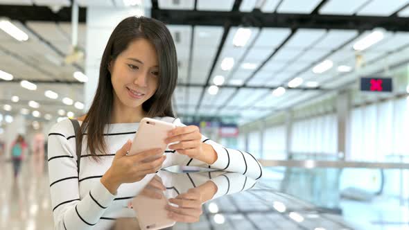 Woman use of cellphone in train station