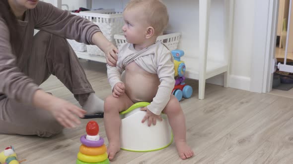 Mother Training Her Baby to Sit on the Potty 1 Year Old Infant Seem Interested in Using the Toilet