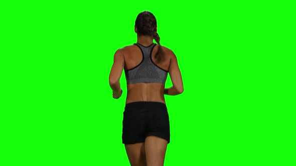 Fit and Muscular Woman Jogging. Back View. Green Screen