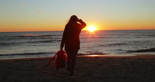 Silhouette of Girl Has Fun By the Ocean at Sunrise on the Beach in Winter